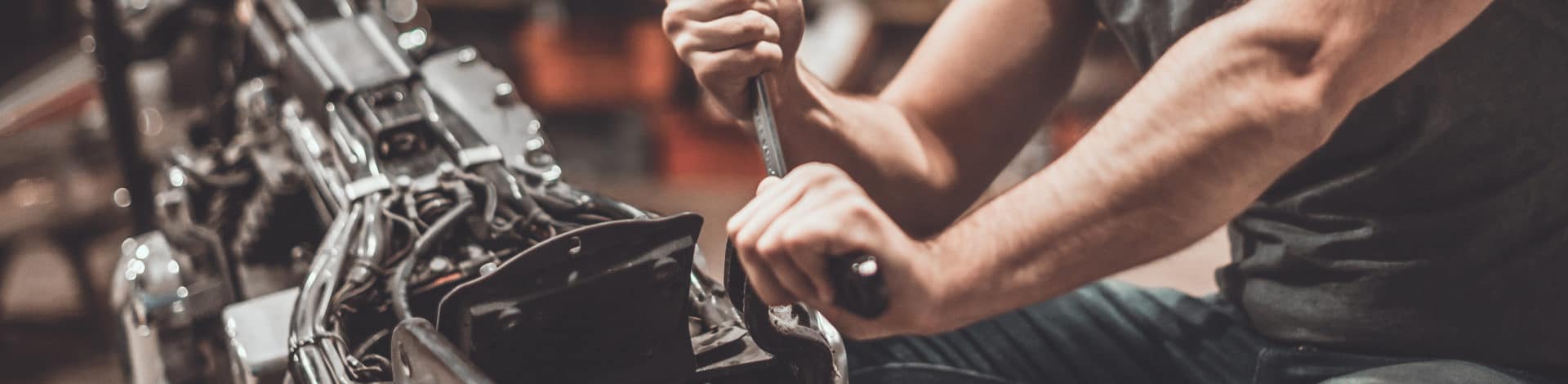 Mechanic working on engine with tools