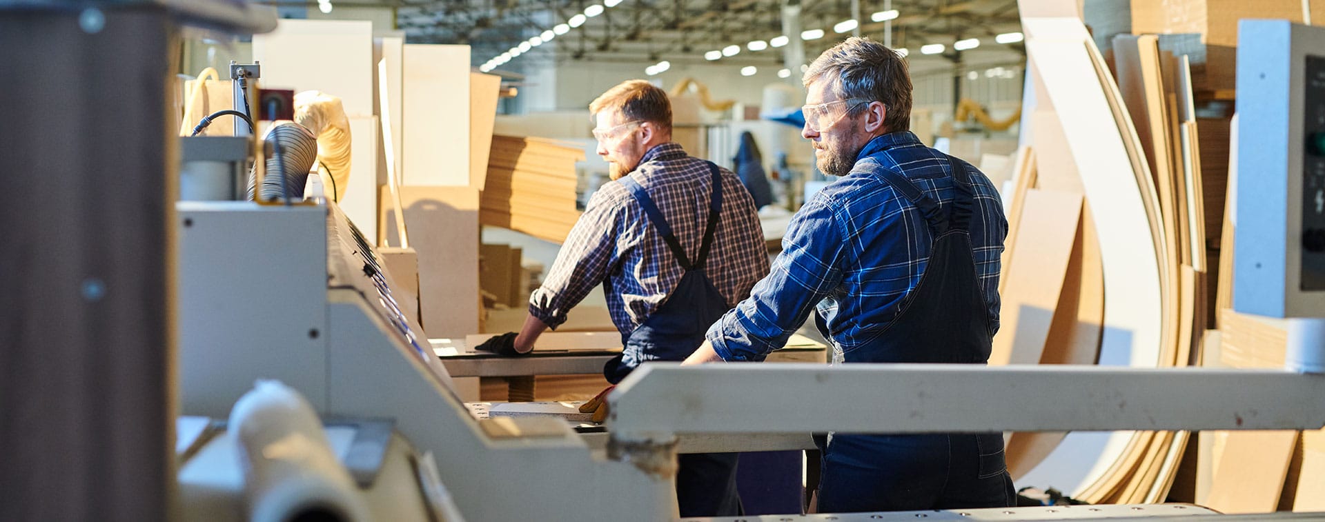 Two men in warehouse constructing furniture