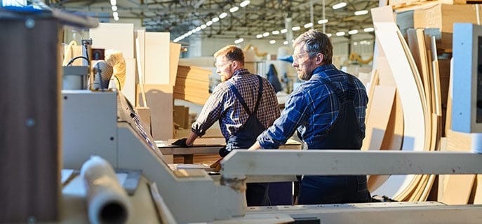 Two men in warehouse constructing furniture